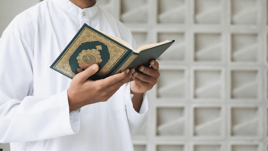 Seorang pelajar tahfiz memegang dan membaca al-Quran dengan penuh khusyuk.