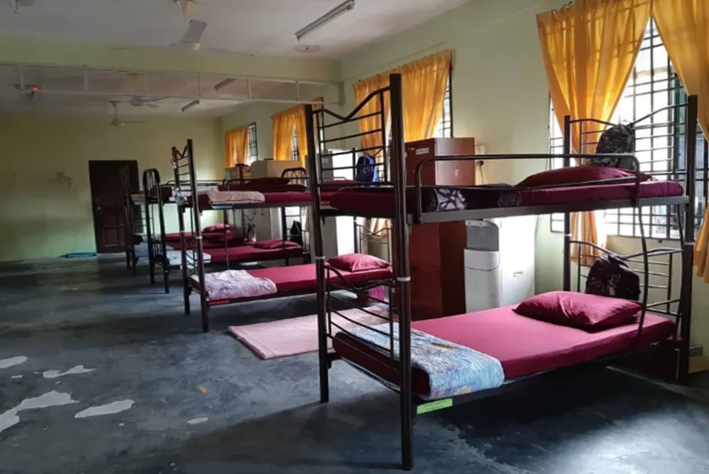 Asrama pelajar tahfiz dengan susunan katil dua tingkat dan suasana bilik yang teratur.