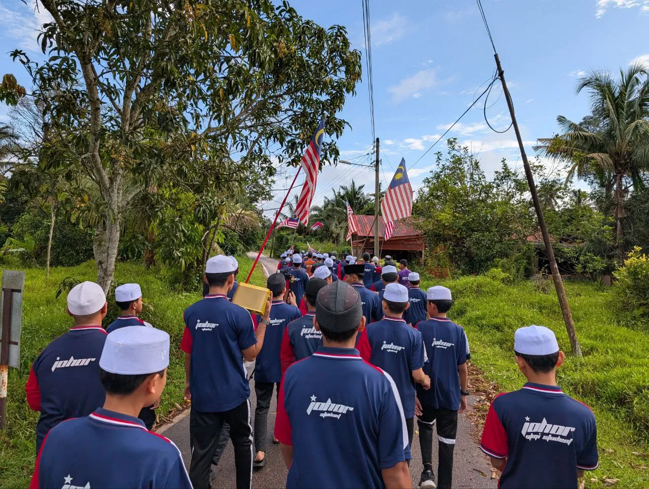 Pelajar tahfiz menyertai perarakan dan aktiviti luar berdisiplin sambil membawa bendera Malaysia.