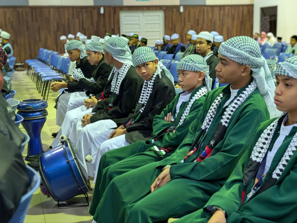 Pelajar tahfiz perempuan memakai jubah hijau menghadiri majlis rasmi atau konvokesyen.