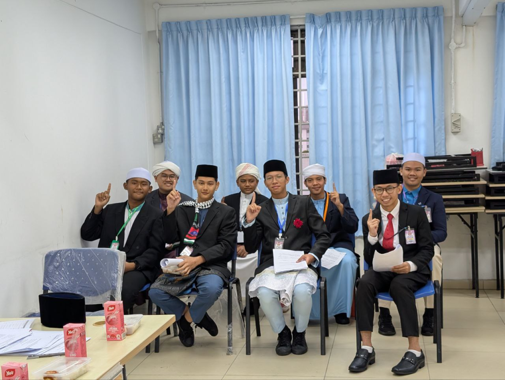 Pelajar tahfiz lelaki menghadiri sesi pembelajaran dan perbincangan di dalam kelas.
