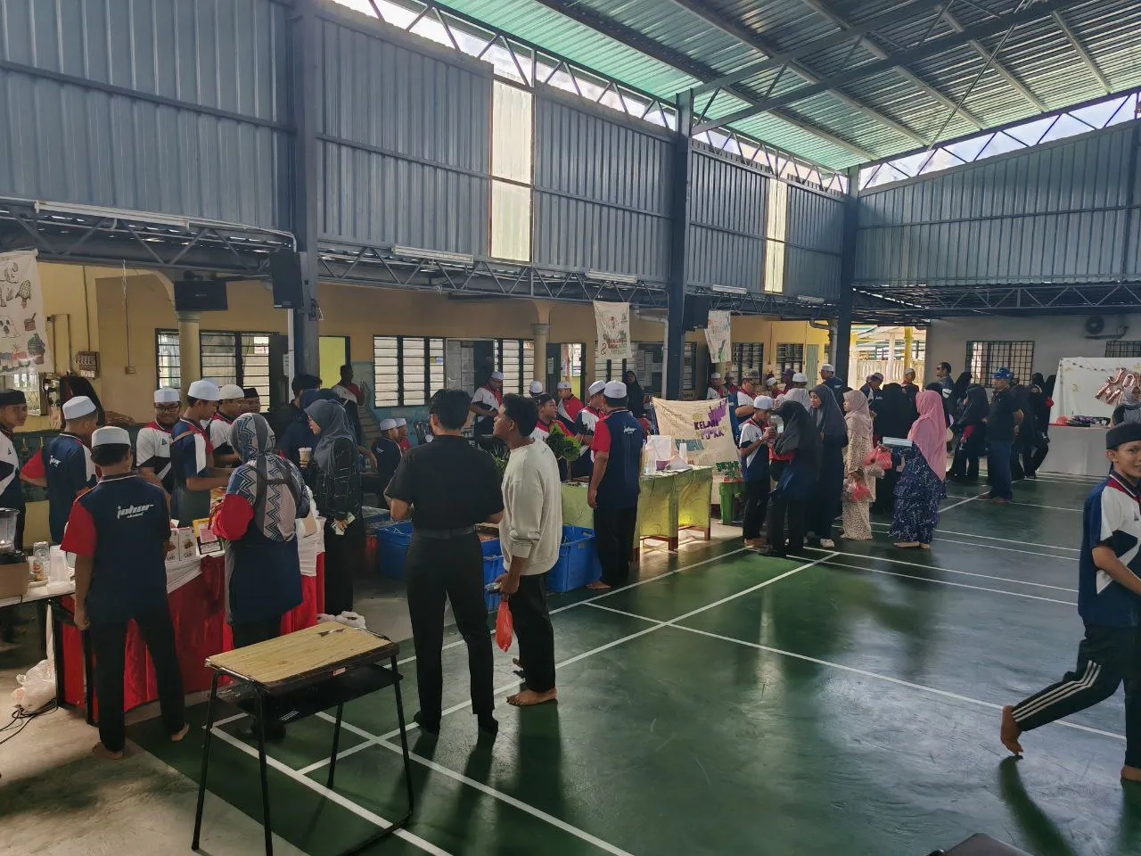 Suasana program komuniti dan kebajikan melibatkan pelajar tahfiz dan masyarakat setempat di dewan.