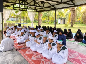 Pelajar tahfiz lelaki dan perempuan berdoa bersama guru dalam suasana pembelajaran Islam